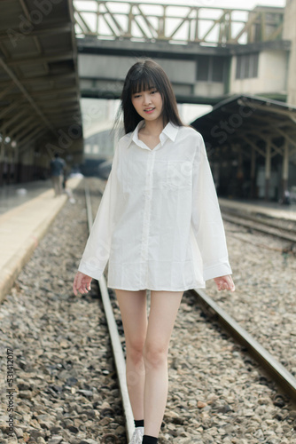 Portrait of thai japan adult beautiful girl white shirt blue jeans relax time, train station fashion