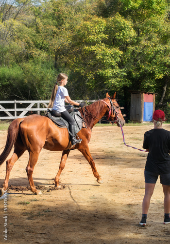 A girl rides a horse to master various elements of horseback riding. © Денис Прохоров