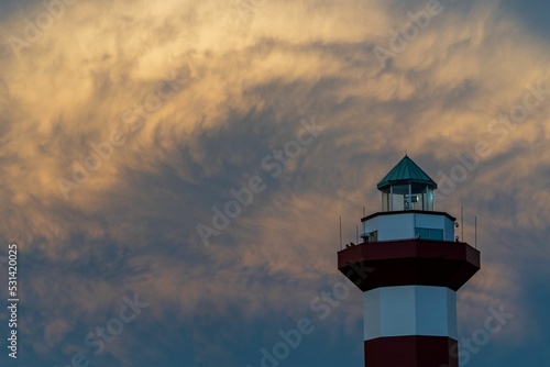 Hilton head lighthouse captured against clouds blocking a sunset photo
