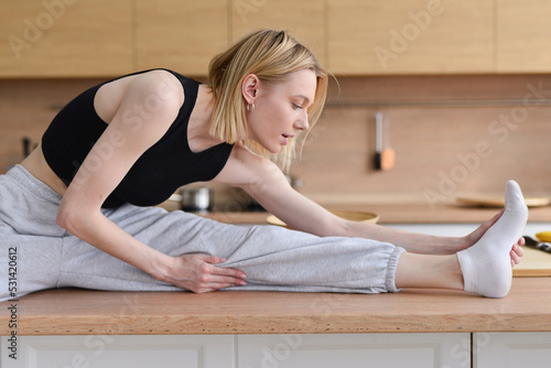 Woman sitting on table doing stretching