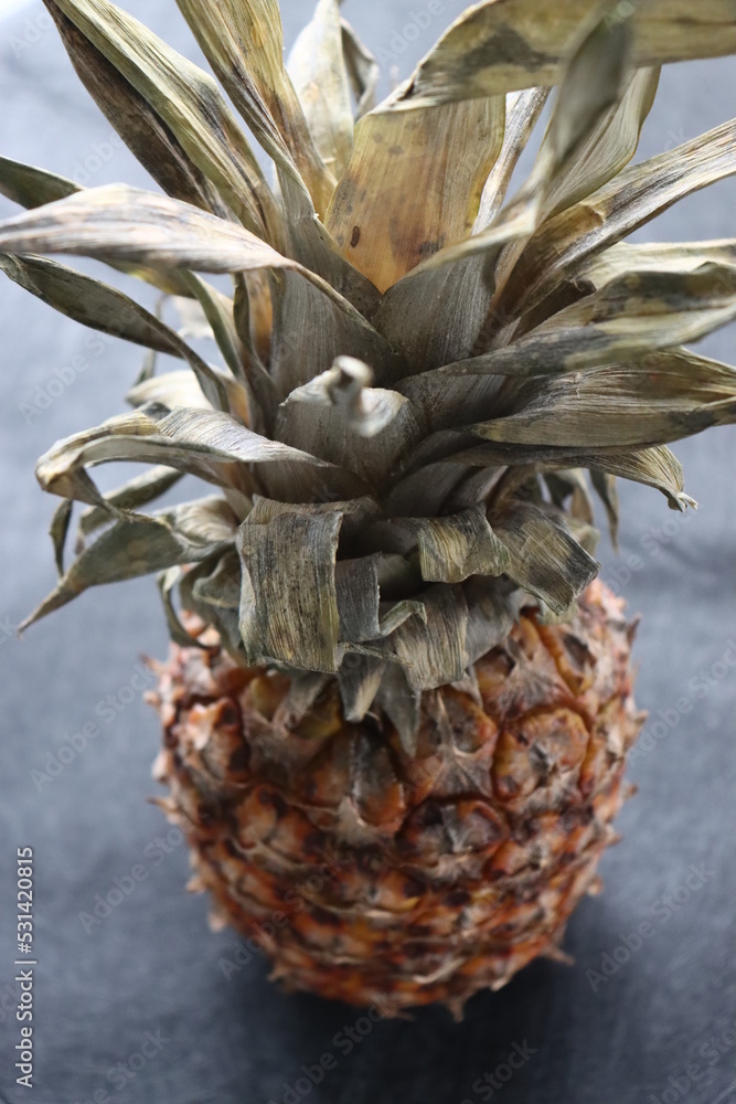 ripe pineapple lies on a black background
