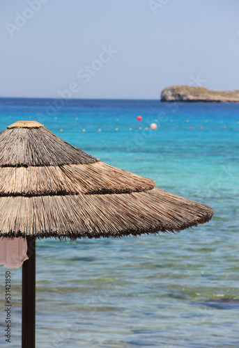 Greek beach and straw sun umbrella.