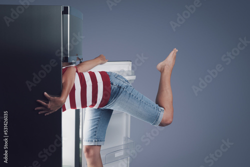 Woman with her head in the fridge photo