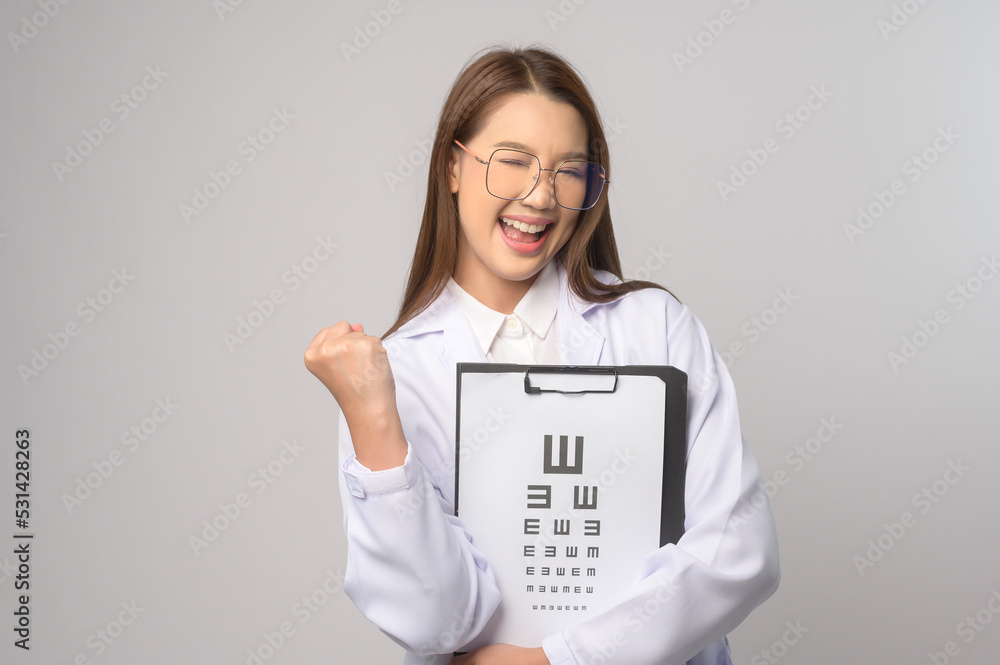 Young female ophthalmologist with glasses holding eye chart over blue background studio, healthcare concept. Young female ophthalmologist with glasses holding eye chart over blue background studio, healthcare concept.