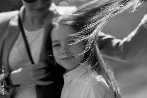 blurred black and white portrait of mother and daughter on a windy day,wind in hair