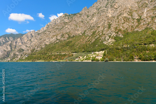 The beautiful Garda lake in Italy  seen from onboard a tourist ferry. It is a beautiful summer day  with just a little bit of clouds.