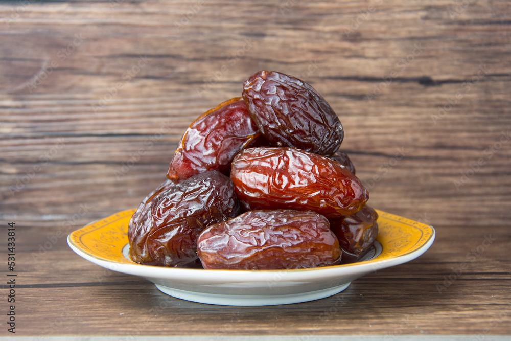 Delicious medjool dates ( kurma ) or sweet dried dates on a plate, as a meal for breaking the fast, ramadan kareem, empty space, copy space. Delicious medjool dates ( kurma ) or sweet dried dates on a plate, as a meal for breaking the fast, ramadan kareem, empty space, copy space.