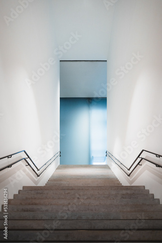 Große minimalistische Treppe mit Geländer in einem leeren Gebäude, optische Täuschung