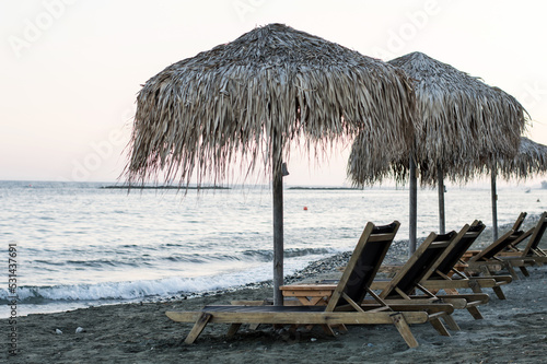 Fototapeta Naklejka Na Ścianę i Meble -  Beach chairs with straw umbrellas on a beautiful tropical beach