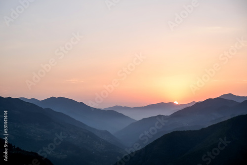 Smoky mountain sunset.Majestic autumn scenery of foggy valley at mountain range at early morning sunrise. Beautiful tonal perspective wide angle panorama © shintartanya