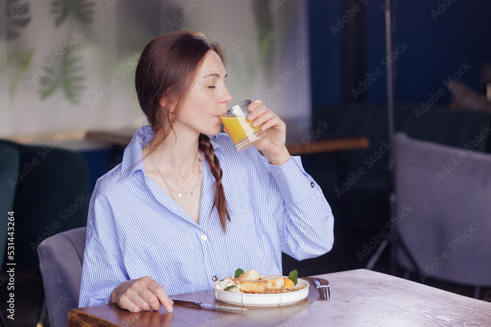 girl drinks juice for breakfast in a modern restaurant girl drinks juice for breakfast in a modern restaurant