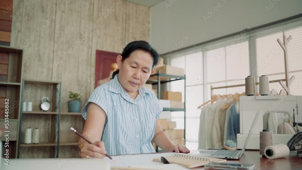 Asian female fashion designer tailor working sketch drawing clothes new collection in studio. Small business owner dressmaker making clothes in work shop, working woman entrepreneur working at home.
Asian female fashion designer tailor working sketch drawing clothes new collection in studio. Small business owner dressmaker making clothes in work shop, working woman entrepreneur working at home.
