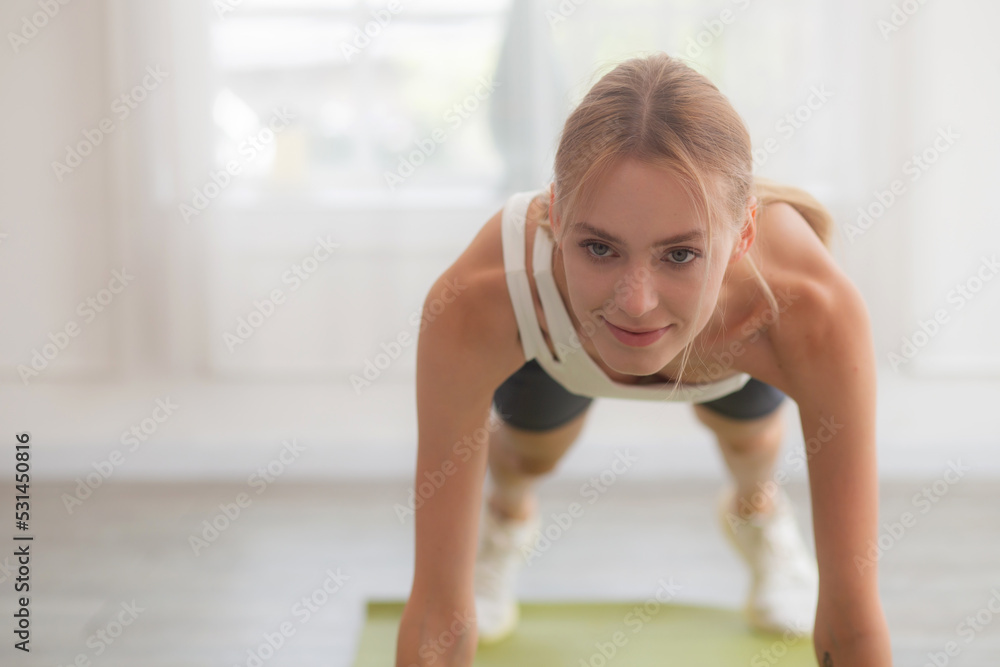 Young woman practice workout with posing plank on mat while motivation and determined at home, female doing weight training with strength and strong, one person, lifestyles and sport concept. Young woman practice workout with posing plank on mat while motivation and determined at home, female doing weight training with strength and strong, one person, lifestyles and sport concept.