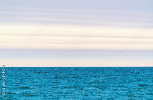 Turquoise sea and horizon with clouds