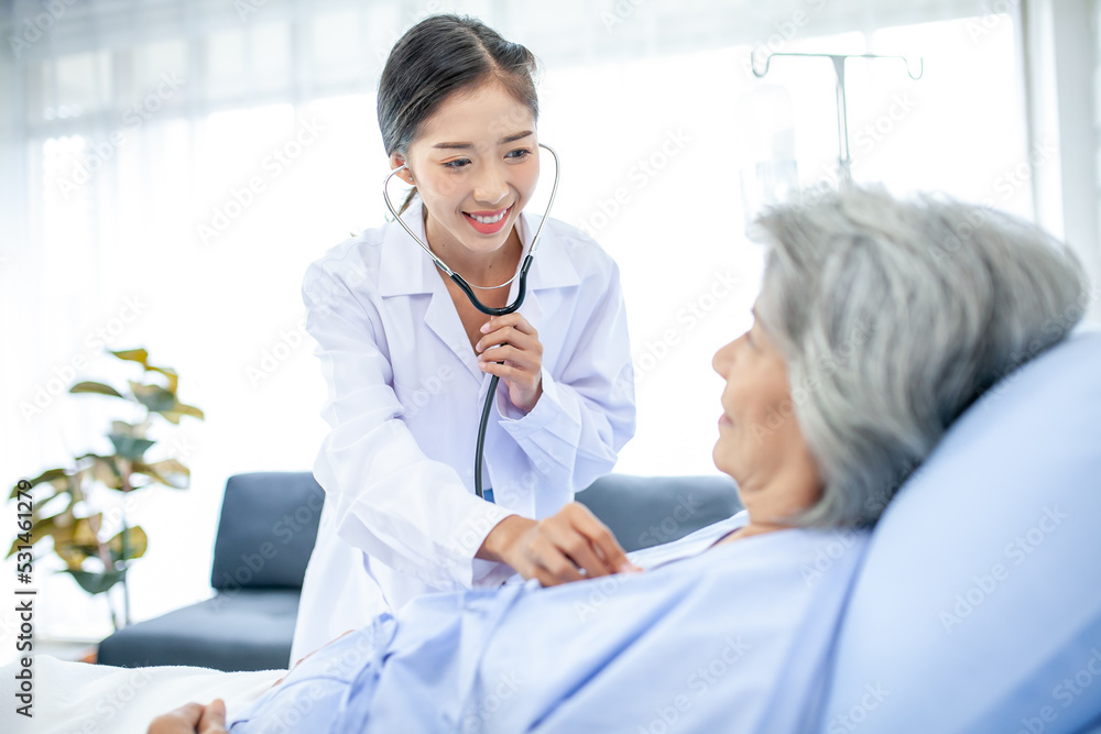 Fototapeta premium Beautiful asian doctor with stethoscope and document folder, examine the symptom for patient in the recovery room. Healthcare and medicine concept.