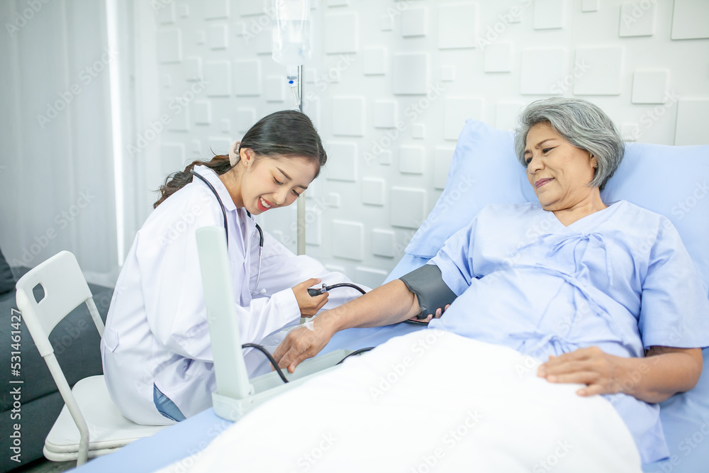 Obraz premium Asian doctor is measuring blood pressure and checking pulse senior patient, Healthcare and medicine concept.