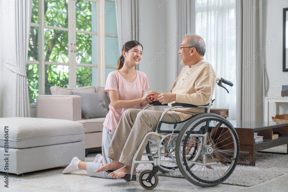 Daughter is caring for and encouraging father who is sick and unable to walk in wheelchair. Daughter is caring for and encouraging father who is sick and unable to walk in wheelchair.