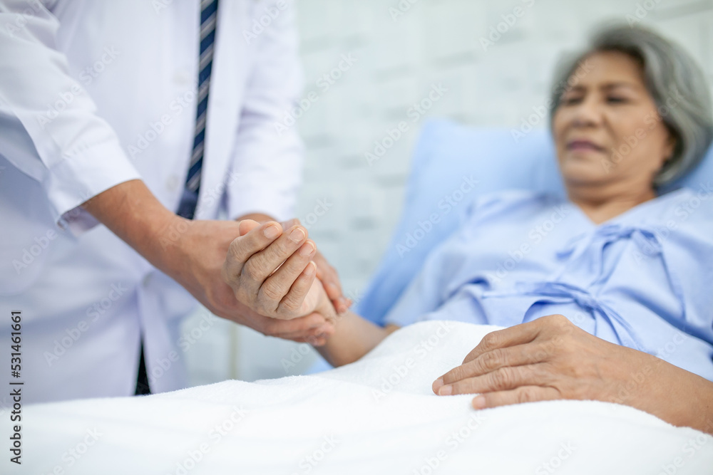 Fototapeta premium Asian doctor supporting and cheering up senior patient in hospital, talking smiling in comfort. Healthcare and medicine concept.