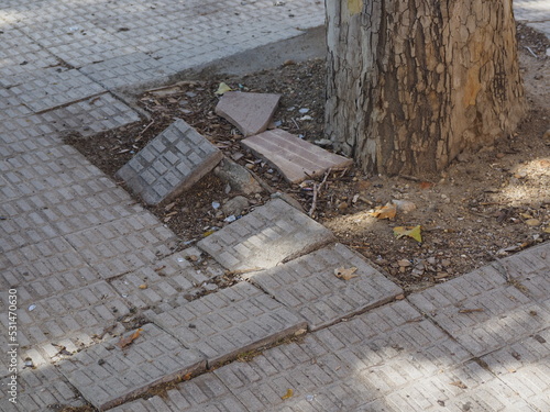 uneven sidewalk tiles. Potholes, insecurity and risk photo