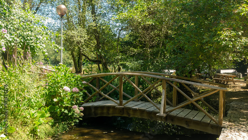 Pedestrian wooden bridge over the river. Walking paths in the natural park