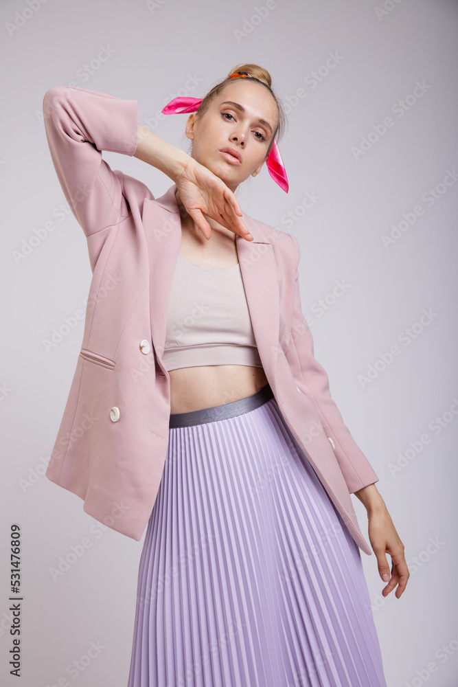 High fashion photo of a beautiful elegant young woman in pretty pink jacket, blazer, lilac lavender skirt posing on white, soft gray background. Studio Shot. Slim Figure, Blonde High fashion photo of a beautiful elegant young woman in pretty pink jacket, blazer, lilac lavender skirt posing on white, soft gray background. Studio Shot. Slim Figure, Blonde