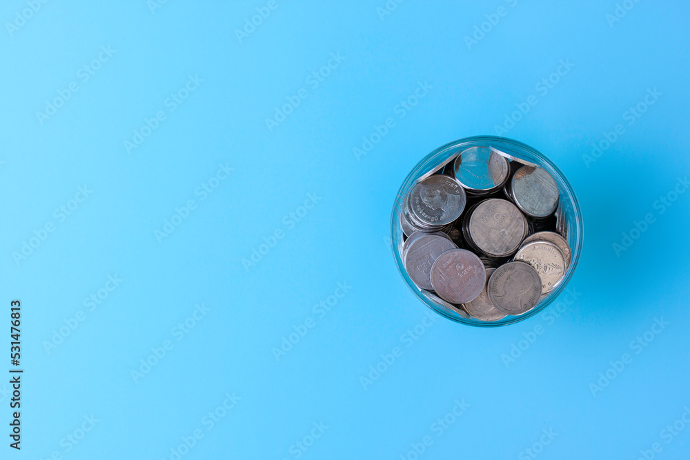 Coins in a glass jar isolated on blue sky background, save money, investment, Thai baht, success life, save, thinking for future, with plan idea concept.