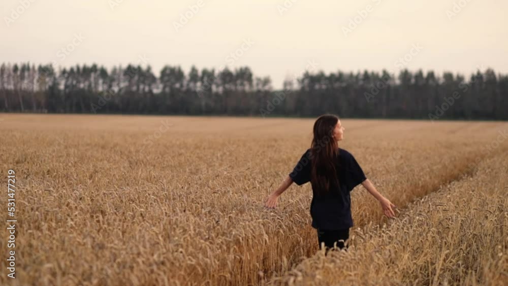 teenager runs through the field of wheat agritourism, happy girl in the summer on the meadow teenager runs through the field of wheat agritourism, happy girl in the summer on the meadow