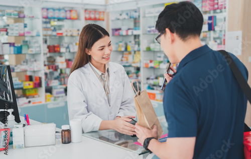 female pharmacist at drugstore.Health care pharmacists work at the hospital.Pharmacist looking at male customer.Doctor specialists organize prescription medications.The customer pay for medicines 