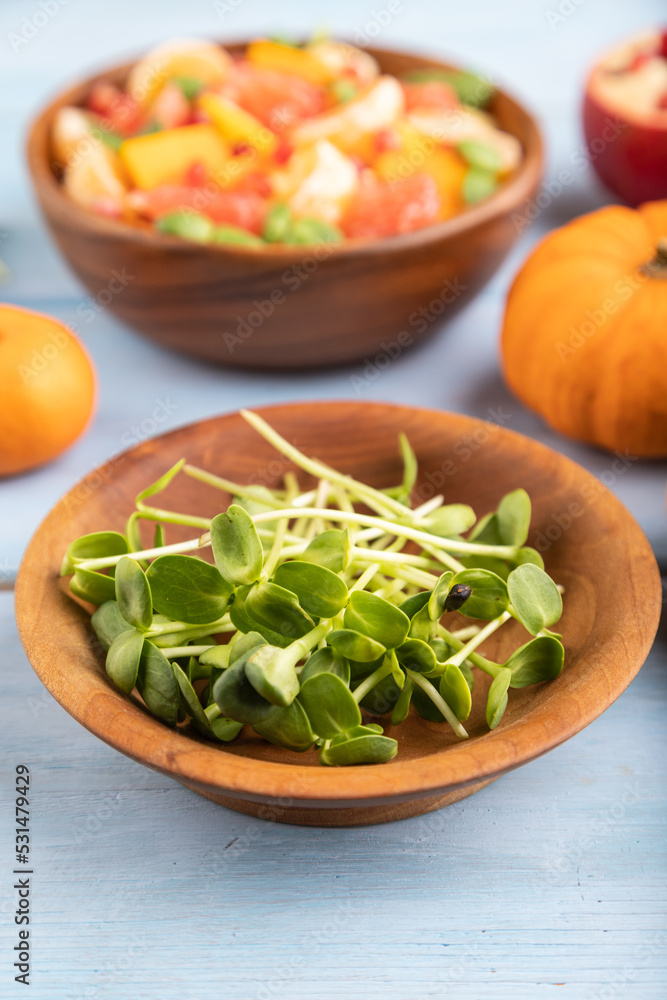 sunflower microgreen sprouts and salad of pumpkin, tangerine, grapefruit side view, selective focus.