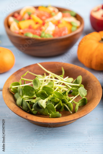 sunflower microgreen sprouts and salad of pumpkin, tangerine, grapefruit side view, selective focus.