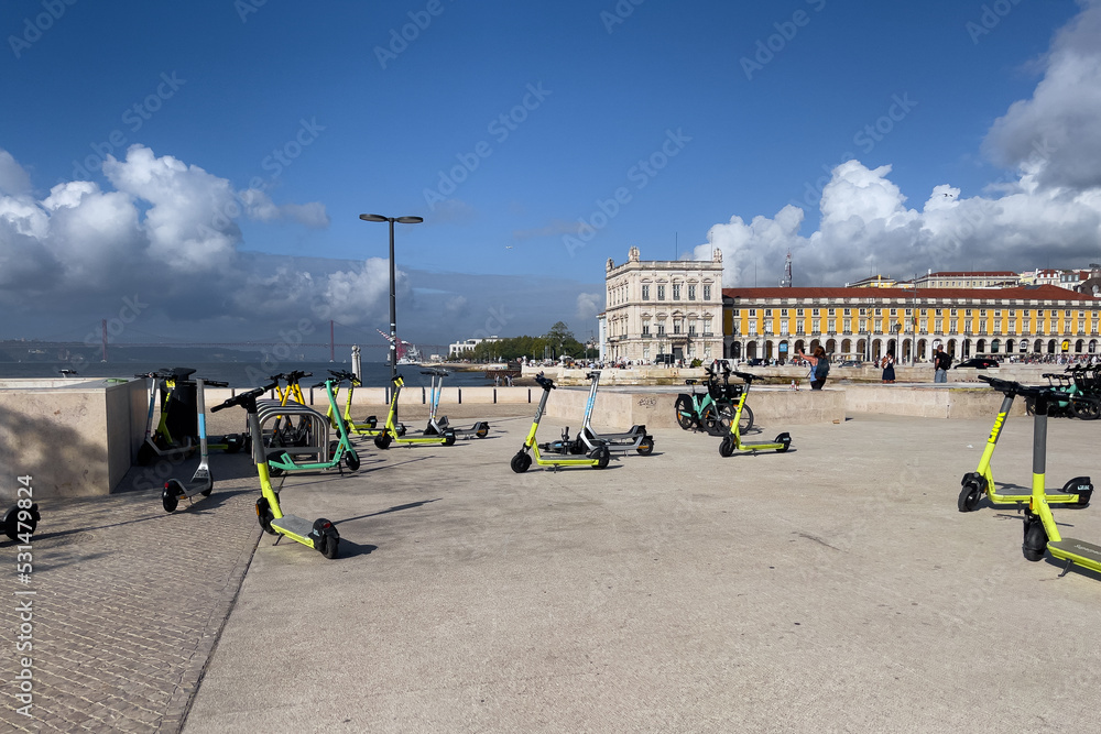 Many electric scooters parked in the square in Lisbon