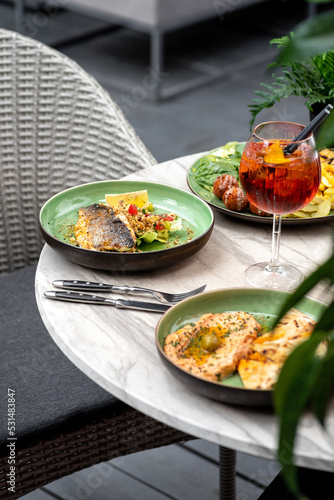 Photography Food on the table summer terrace, grilled sea bass fillet and hummus