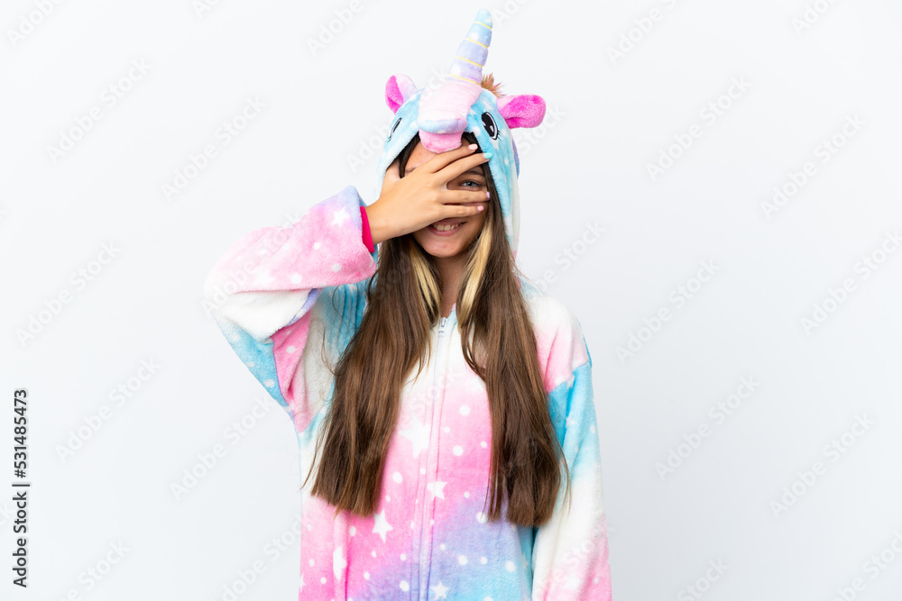 Little caucasian girl wearing unicorn pajama isolated on white background covering eyes by hands and smiling Little caucasian girl wearing unicorn pajama isolated on white background covering eyes by hands and smiling