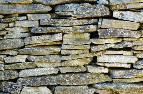 Muro de lajas de piedra con musgo y l  quenes
