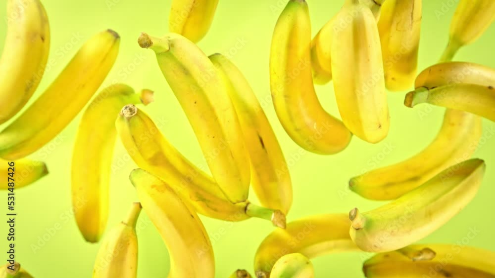 Super Slow Motion Shot of Fresh Bananas on Green Background Flying Towards Camera at 1000fps. Super Slow Motion Shot of Fresh Bananas on Green Background Flying Towards Camera at 1000fps.