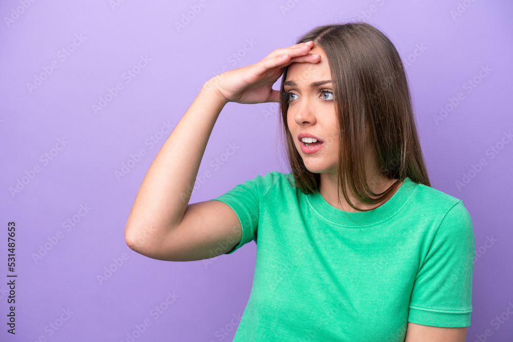 Young caucasian woman isolated on purple background with surprise expression while looking side Young caucasian woman isolated on purple background with surprise expression while looking side