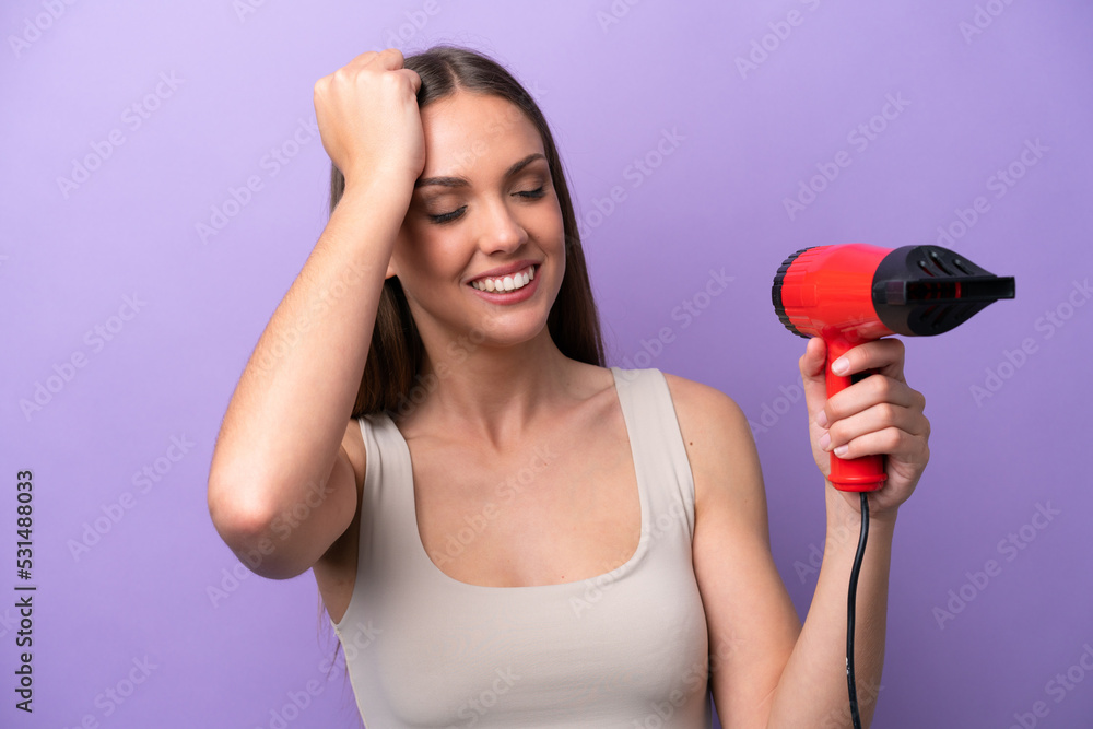 Young caucasian woman holding a hairdryer isolated on purple background has realized something and intending the solution Young caucasian woman holding a hairdryer isolated on purple background has realized something and intending the solution