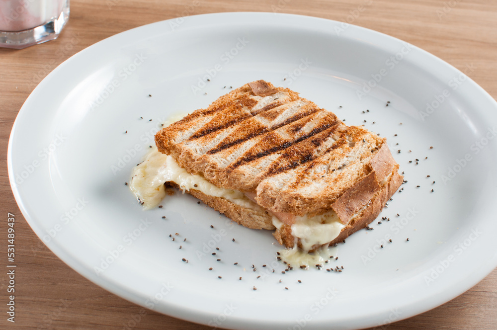 Misto-quente, ou torrada, com pão de fôrma e queijo muçarela acompanhado de um copo de vitamina feito com frutas vermelhas e yogurte natural Misto-quente, ou torrada, com pão de fôrma e queijo muçarela acompanhado de um copo de vitamina feito com frutas vermelhas e yogurte natural