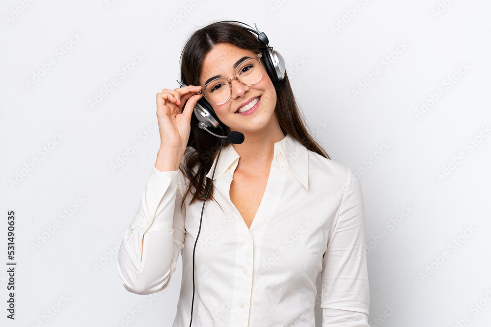 Telemarketer caucasian woman working with a headset isolated on white background with glasses and happy Telemarketer caucasian woman working with a headset isolated on white background with glasses and happy