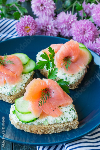 Fish appetizer. Bruschetta with salmon, cottage cheese and cucumber. Valentine's Day Appetizer
