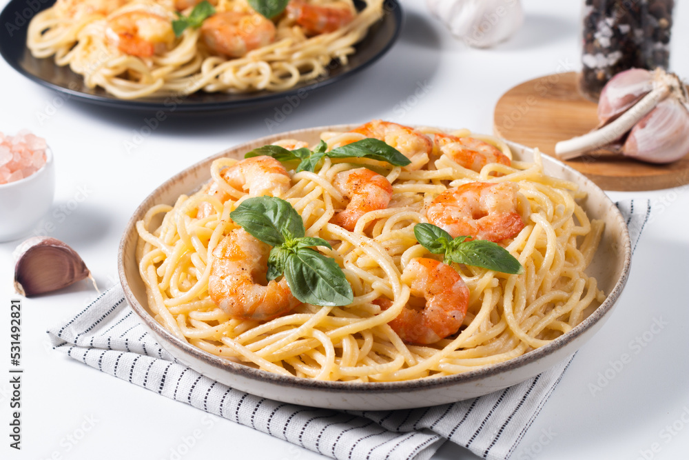 Italian pasta spaghetti with soft cheese sauce with shrimp or prawns on a plate Italian pasta spaghetti with soft cheese sauce with shrimp or prawns on a plate