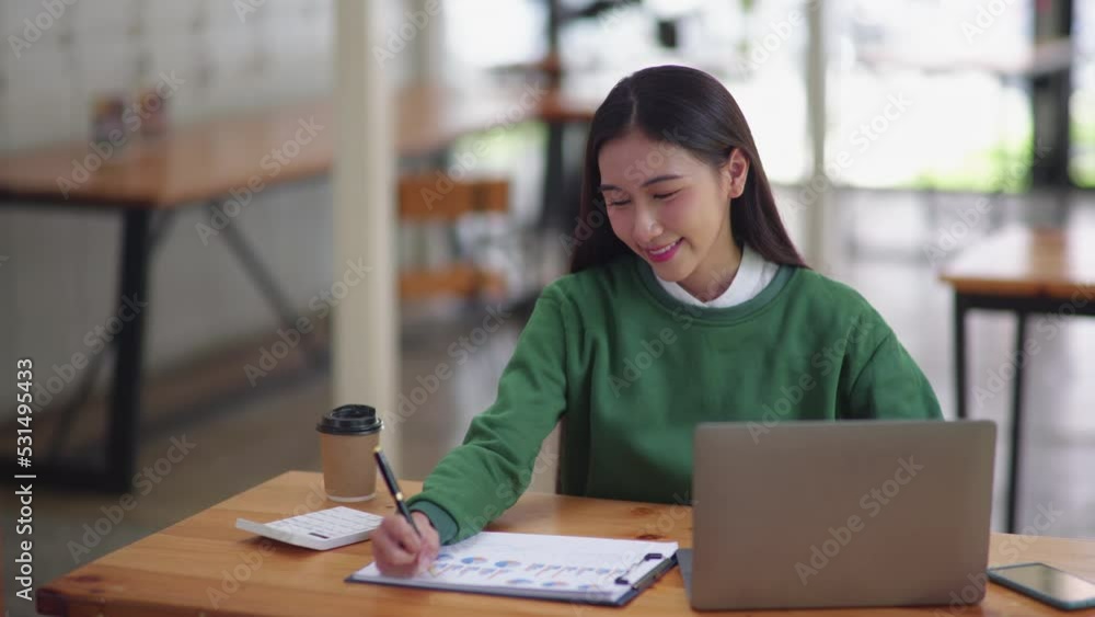 Young beautiful is studying online via laptop and writing on note book at home. Young beautiful is studying online via laptop and writing on note book at home.