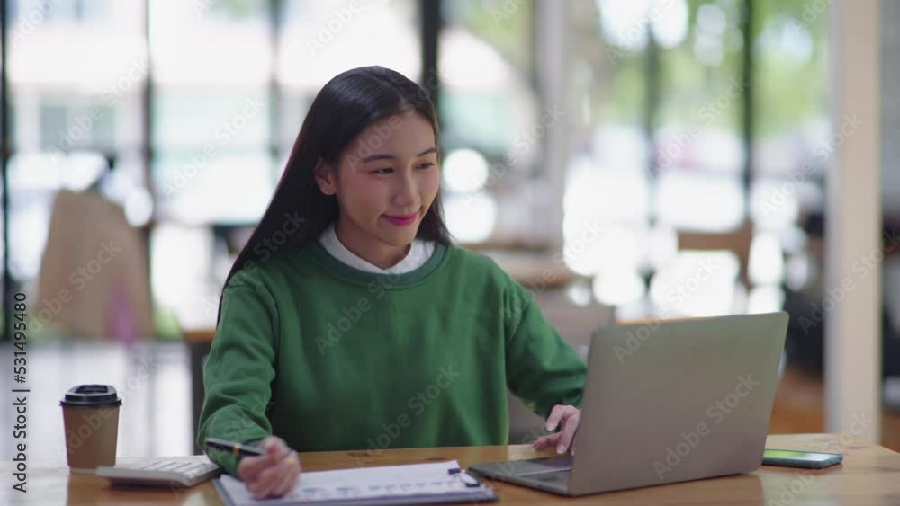 Young beautiful is studying online via laptop and writing on note book at home. Young beautiful is studying online via laptop and writing on note book at home.