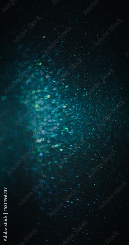 Particles texture background. Bokeh light flare. Blur glitter. Defocused blue green color sparkles on dark night black abstract poster. Particles texture background. Bokeh light flare. Blur glitter. Defocused blue green color sparkles on dark night black abstract poster.