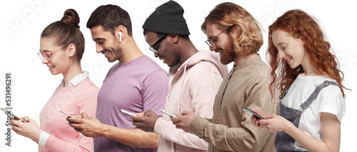 Interracial happy young men and women standing in row, using smartphones photo