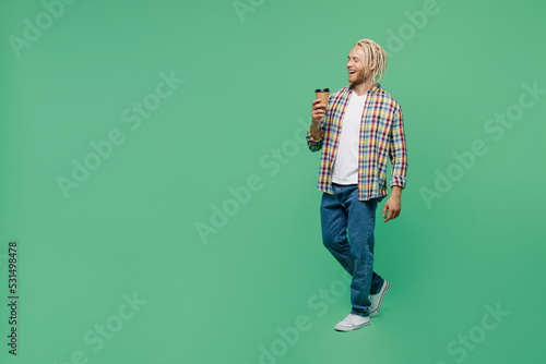 Full body young blond man with dreadlocks 20s he wear casual shirt hold takeaway delivery craft paper brown cup coffee to go isolated on pastel plain light green background. People lifestyle concept.