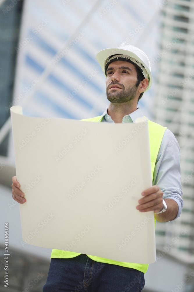 Architect or engineer with blueprints. Cauacsian Engineer checking plan on construction site. modern structure. Architect or engineer with blueprints. Cauacsian Engineer checking plan on construction site. modern structure.