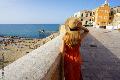 Obraz na plátně Back view of young woman walking in the historic town of Termoli, Molise, Italy