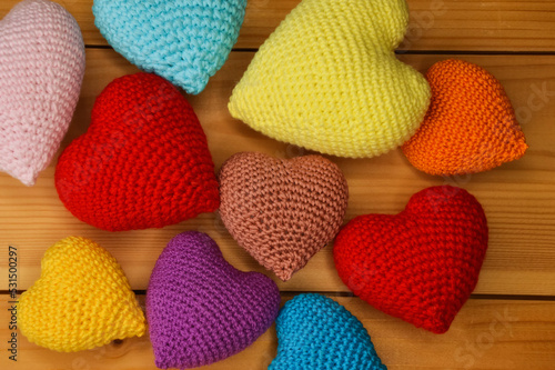 multicolored knitted hearts on a wooden background. valentine's Day. love.