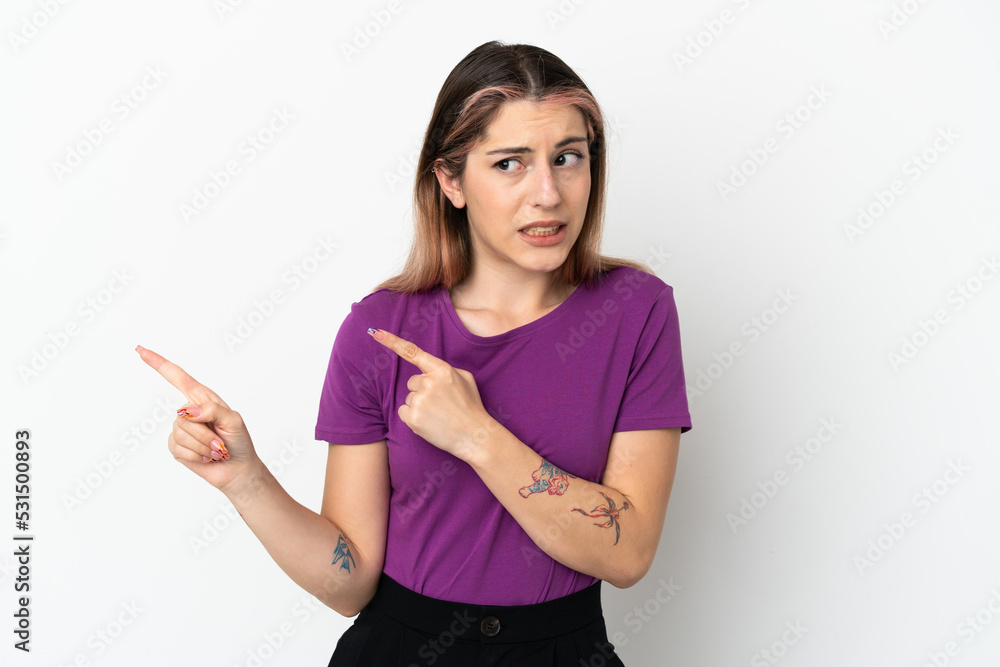 Young caucasian woman isolated on white background frightened and pointing to the side Young caucasian woman isolated on white background frightened and pointing to the side